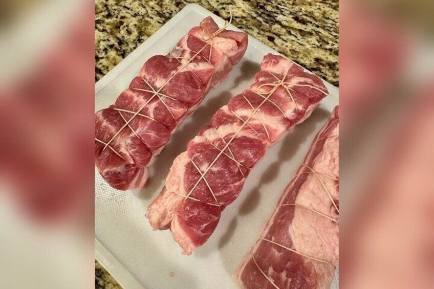 Raw meat tied with string on a cutting board. 4