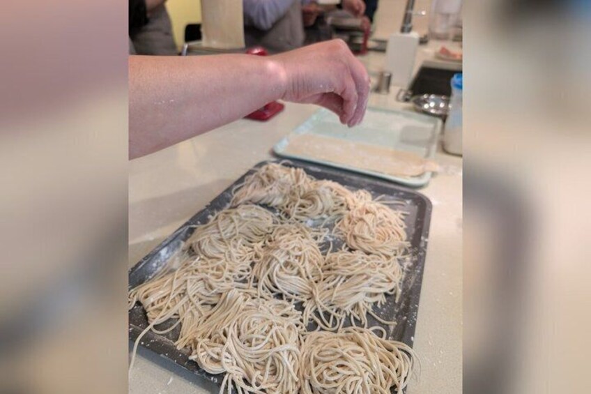 A person preparing pasta on a kitchen counter. 5