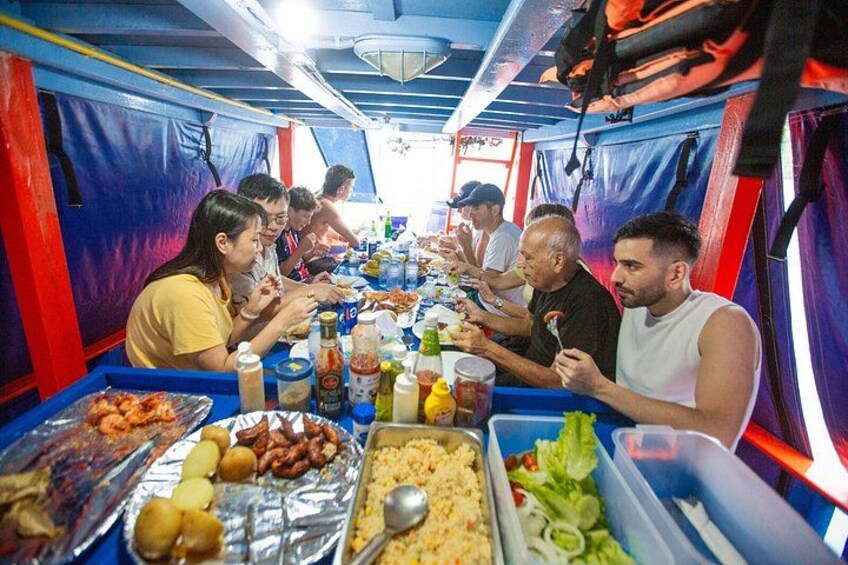 A group of people dining at a table with various dishes and condiments. 4