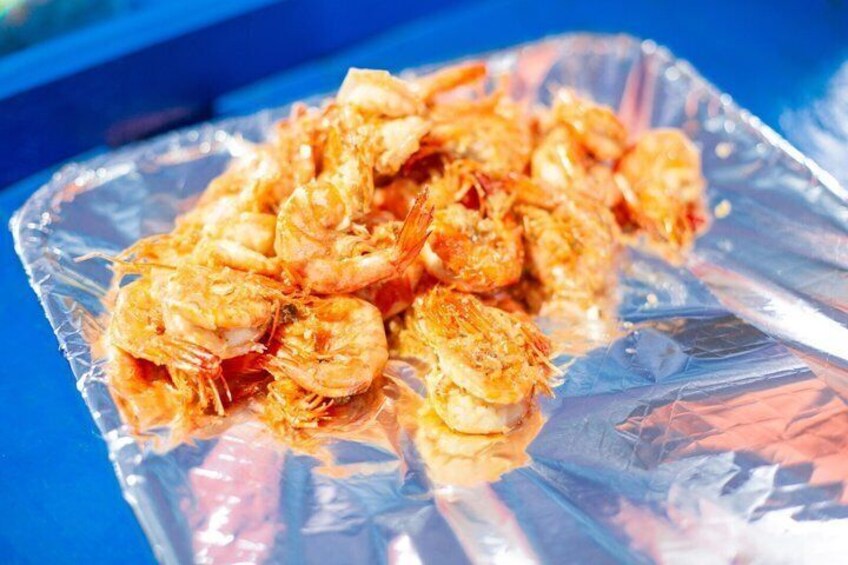 A pile of cooked shrimp on a clear plastic tray. 5