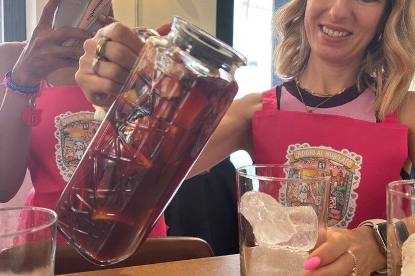 A person pouring a dark liquid from a jar into a glass. 3