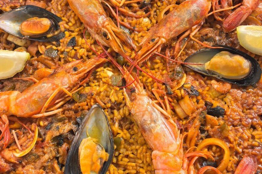 A seafood paella with shrimp, mussels, and lemon slices. 2