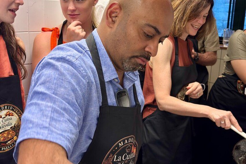 A person in a blue shirt and apron, with a logo that reads 'La Cuna.' 4
