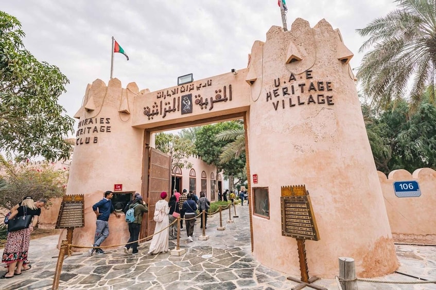 The entrance to the U.A.E. Heritage Village with stone architecture and a signboard. 3