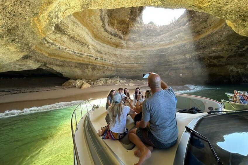 A boat tour with people observing a cave formation. 2