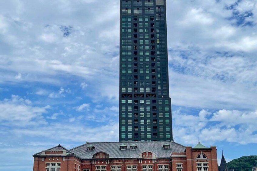 A tall modern skyscraper with a red brick building in front. 4