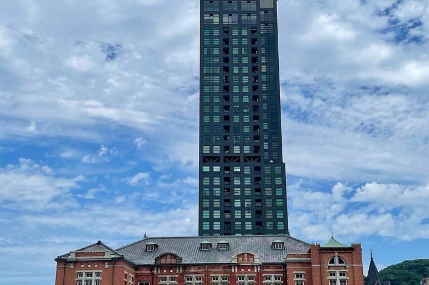 Un rascacielos alto y moderno con un edificio de ladrillo rojo al frente. 5