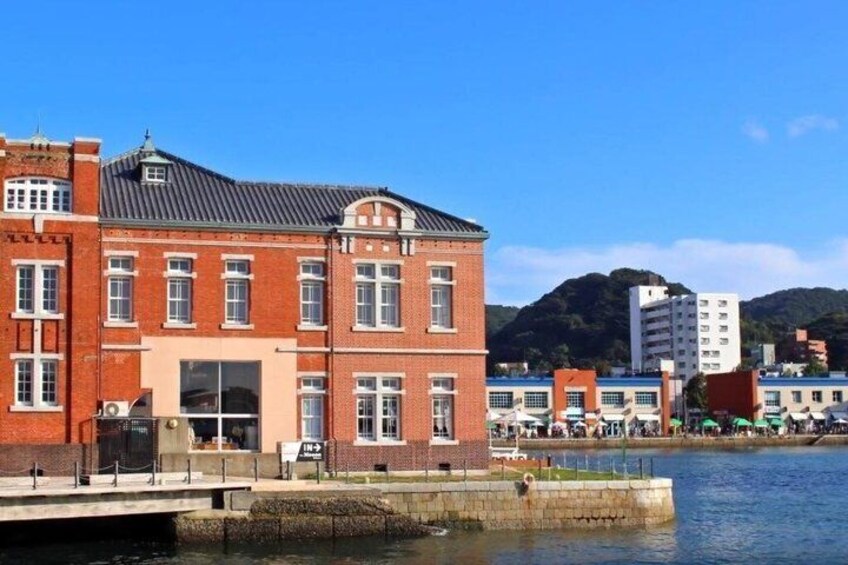 A red brick building with a flat roof, a dock, and a mountain in the background. 3