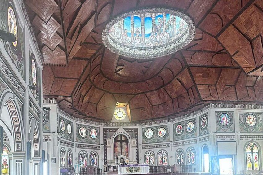 A grand hall with a high, vaulted ceiling, intricate stained glass windows, and a large circular stained glass window at the center. 2