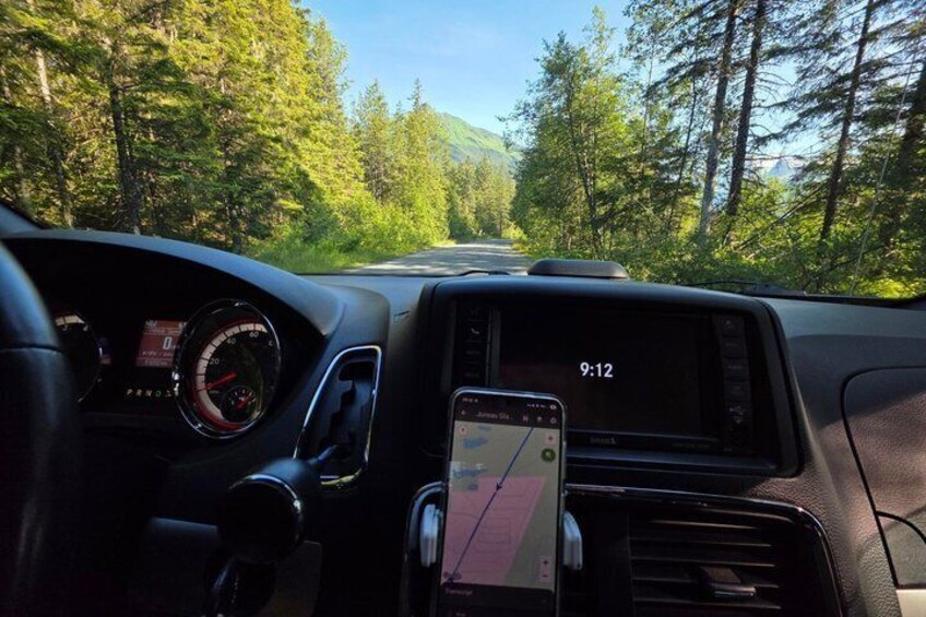 A car dashboard with a GPS device, a speedometer, and a clock displaying 9:12. 3