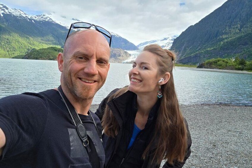 A person taking a selfie with a mountainous landscape in the background. 2