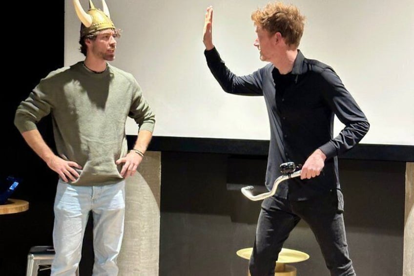 Two people in a room, one wearing a horned helmet and the other holding a sword. 3