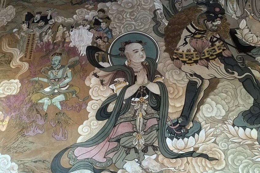 A mural with a central figure in traditional attire, surrounded by other figures and floral patterns. 5