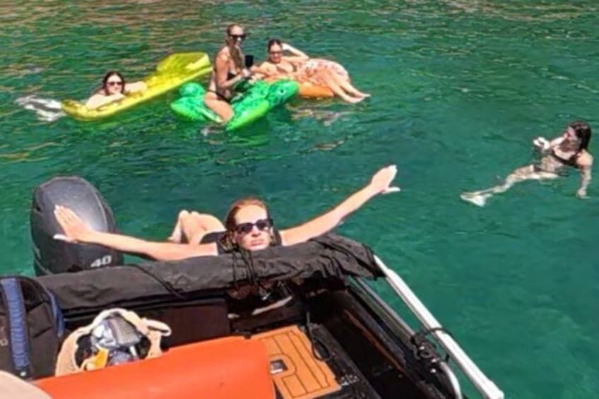 A boat with people on inflatable rafts in the water. 5