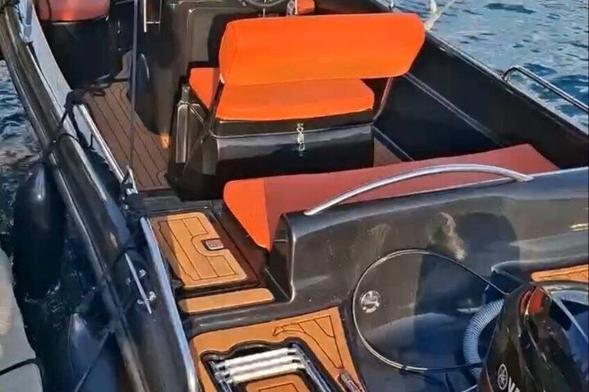 A boat interior with orange seating and wooden paneling. 3