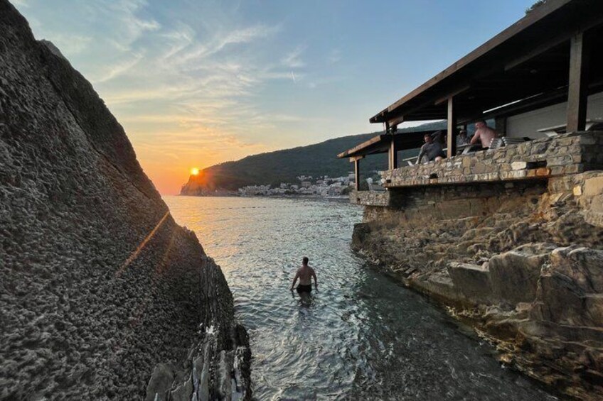 A person swimming in a narrow water channel with a sunset in the background. 4