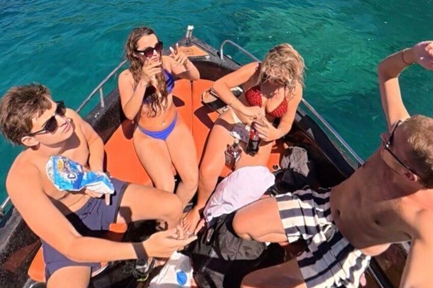 A group of people on a boat with clear blue water. 4