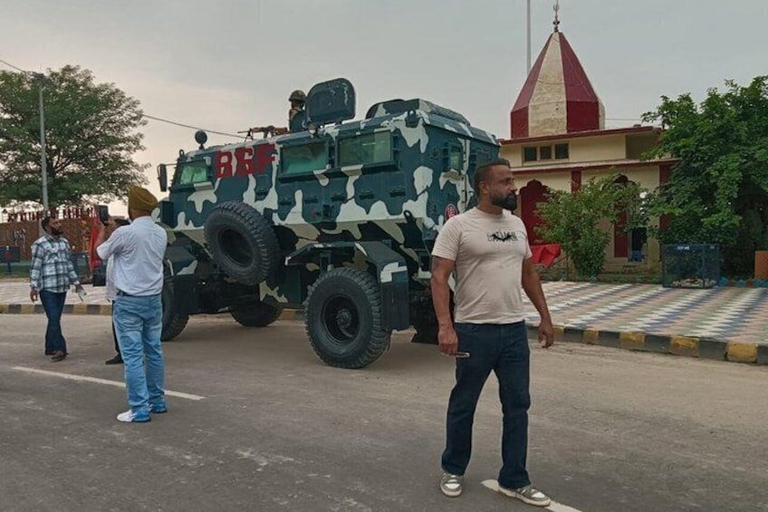 A military vehicle with camouflage pattern and the letters 'BSE' on the side parked on a street. 1