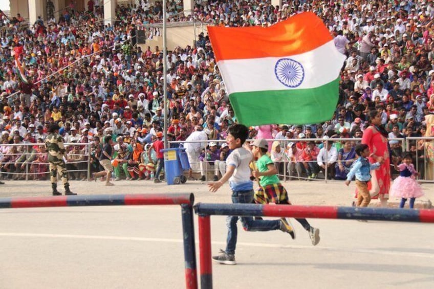 A crowd of people, a flag, and a hurdle. 2
