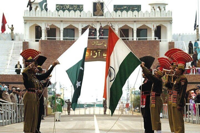 A ceremonial event with military personnel holding flags in front of a building with arches. 3