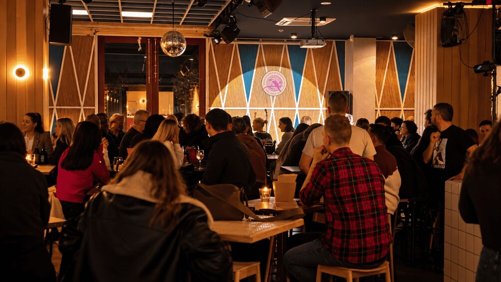 A crowded indoor dining area with wooden walls and tables. 3