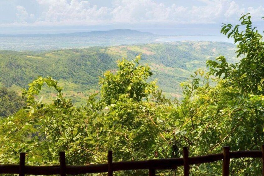 A lush green landscape with a wooden fence in the foreground. 2