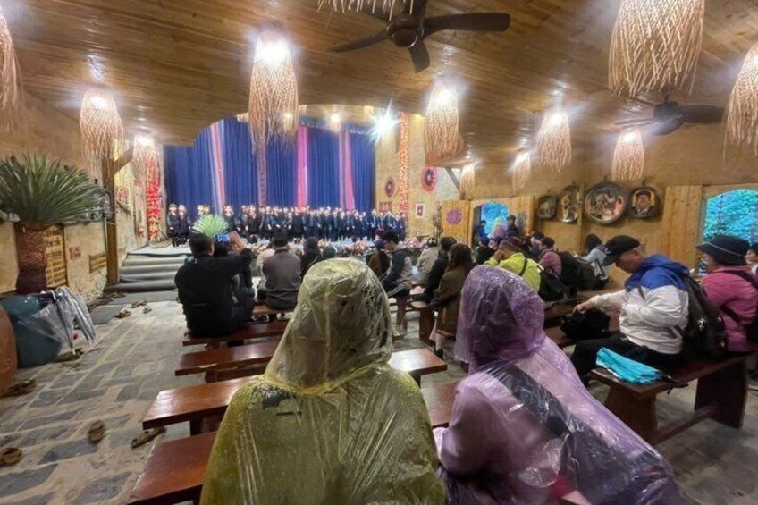 A group of people seated in a hall with a stage at the front. 5