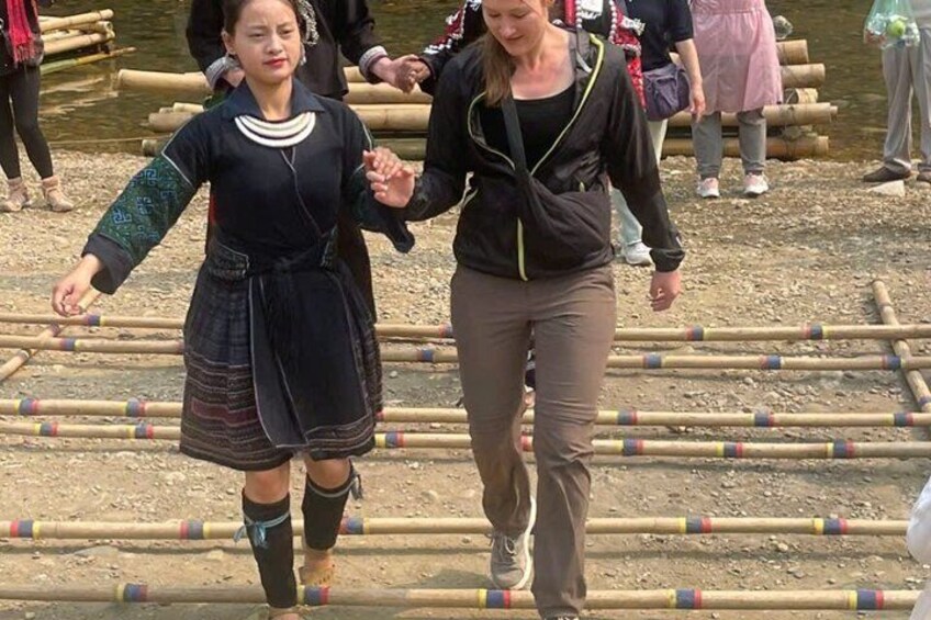 Two people walking on a wooden bridge over a body of water. 2