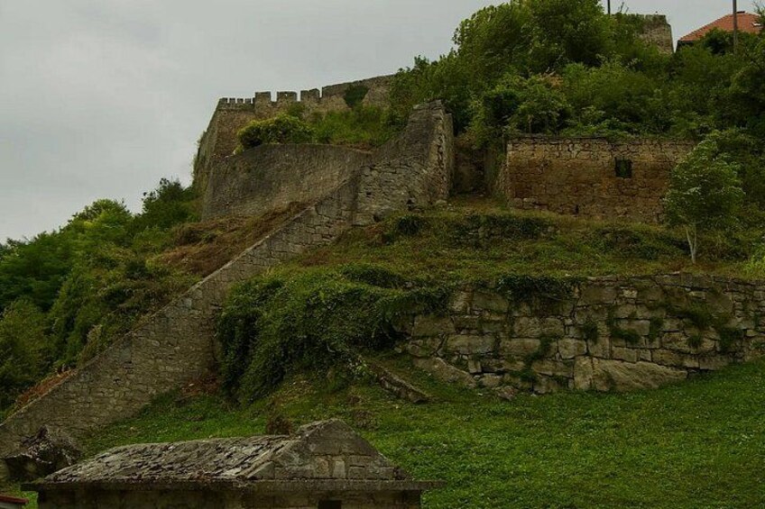 A historic stone fortification with a ramp and a small building at its base. 4