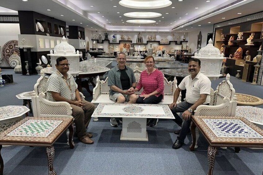 A group of people seated at tables with chessboards in a furniture store. 3