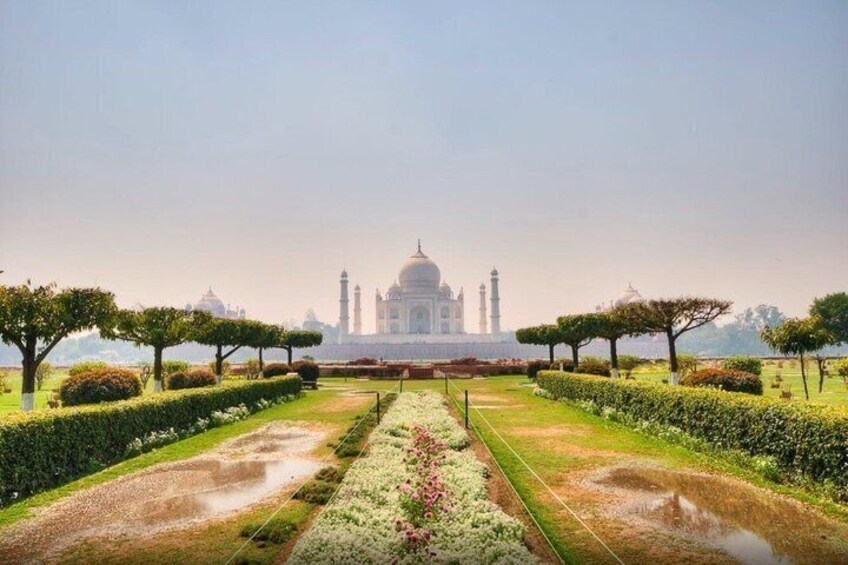 The Taj Mahal with a symmetrical garden layout, a central water feature, and four minarets. 4