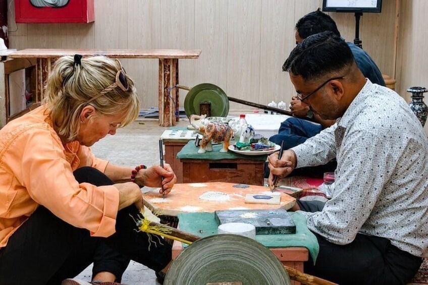 Two people engaged in a craft activity at a table with various tools and materials. 5
