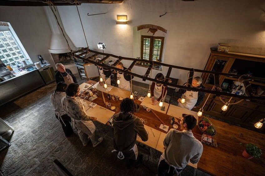 A kitchen with chefs preparing food, hanging lights, and a window overlooking the city. 4