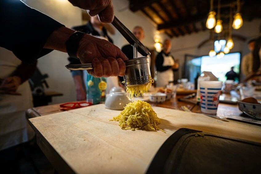 A person grating cheese on a wooden cutting board in a kitchen setting. 2