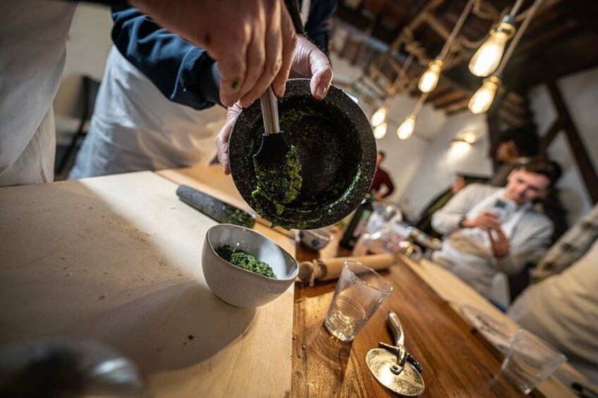 A person grinding herbs in a kitchen setting. 5