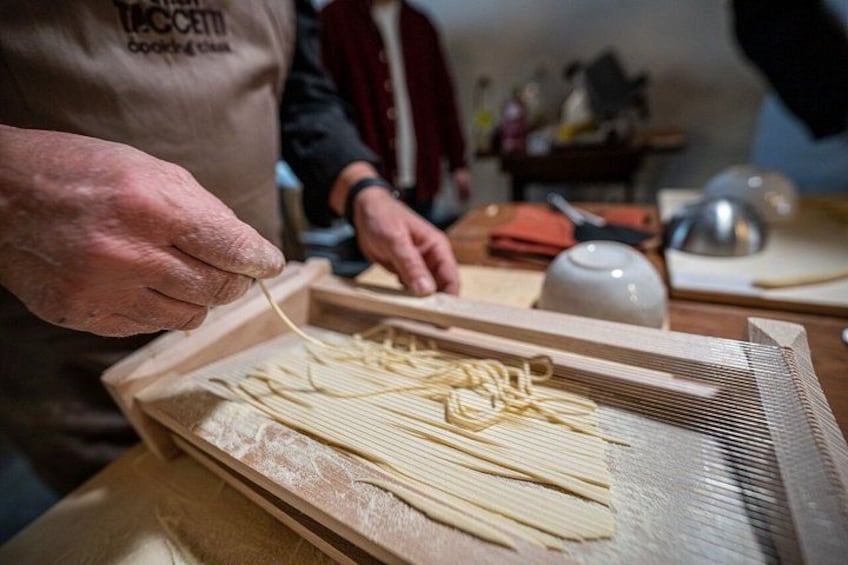 A person preparing pasta on a wooden board. 2