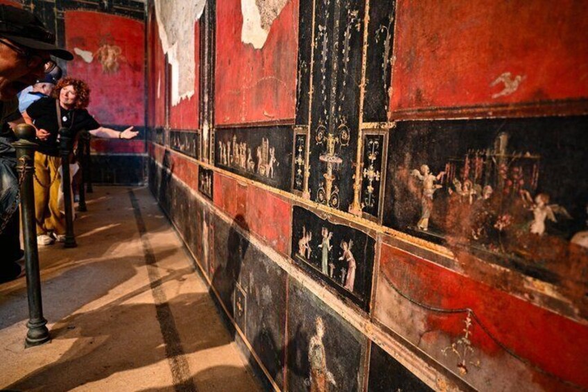 A corridor with red walls, black panels, and white figures. 3