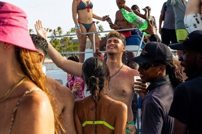 A crowded beach with people in swimwear and a lifeguard tower in the background. 3