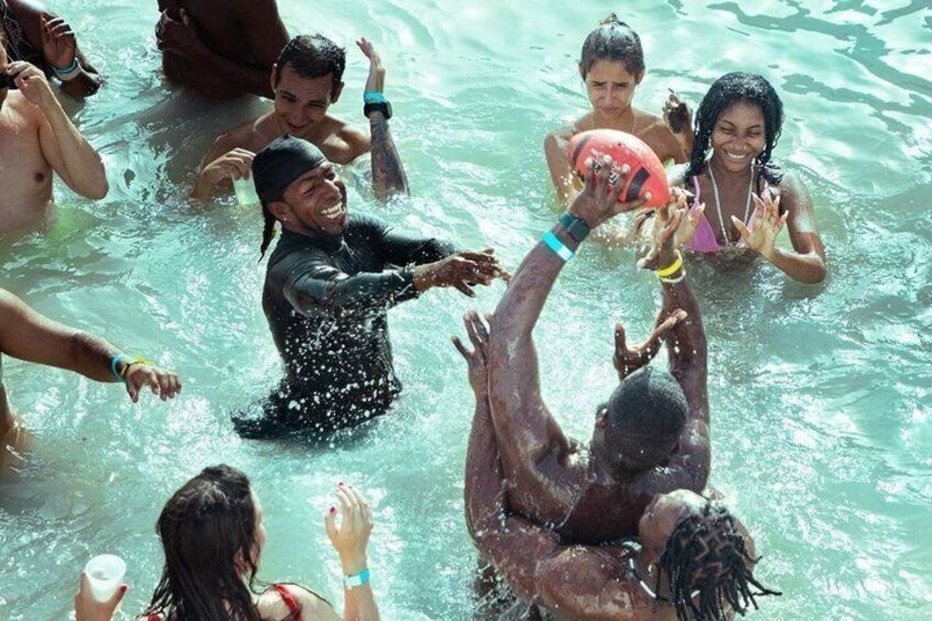 People playing with a ball in a body of water. 4