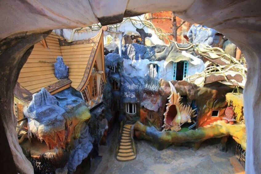 A whimsical indoor scene with a wooden structure, a small house, and a slide. 3