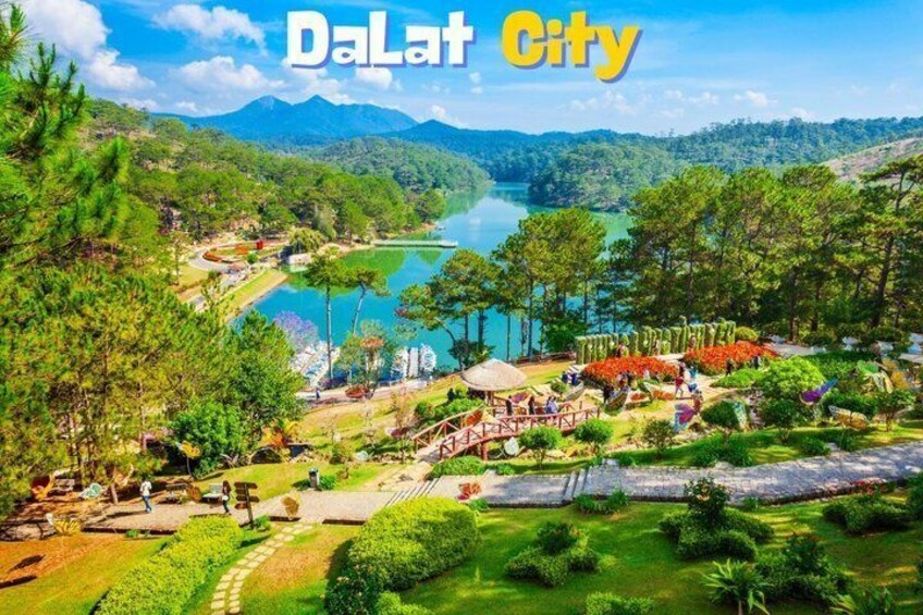 A scenic view of Dalat City with a lake, lush greenery, and a clear sky. 1