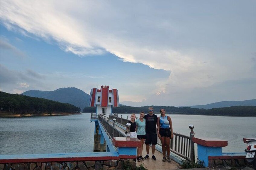 A pier with a red and blue structure, a lake, and mountains in the background. 5