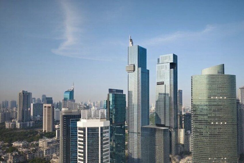 A cityscape with modern skyscrapers, including a distinctive curved building and a tall rectangular building with a spire. 4