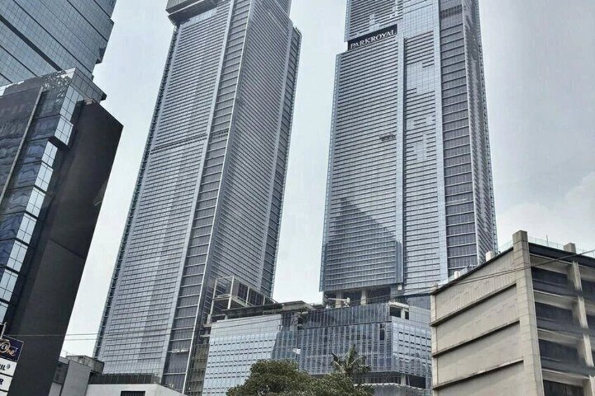 Two tall, modern skyscrapers with reflective glass facades, surrounded by other buildings. 3