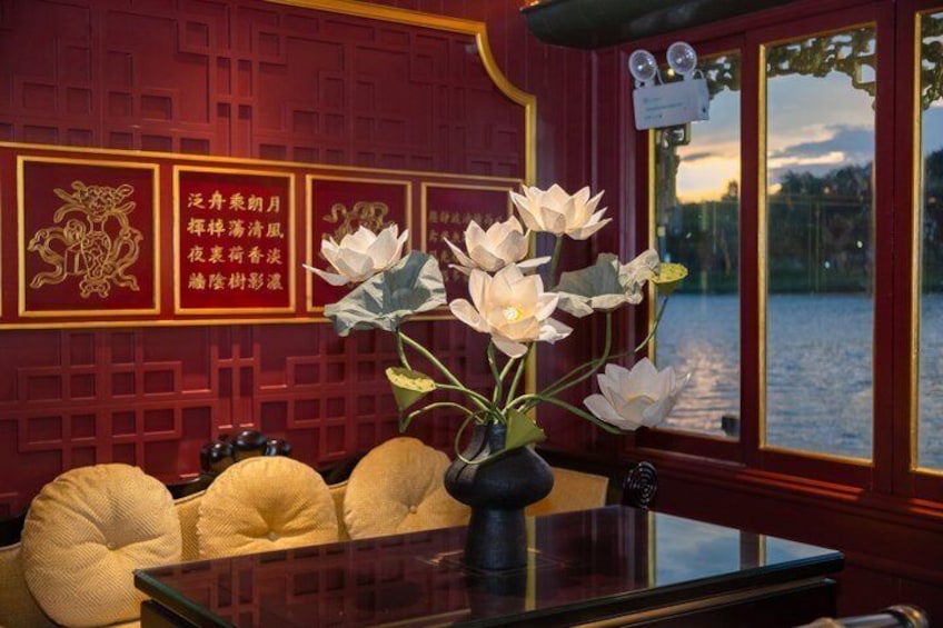 A traditional Chinese interior with red walls, a wooden table, and a vase of white flowers. 3