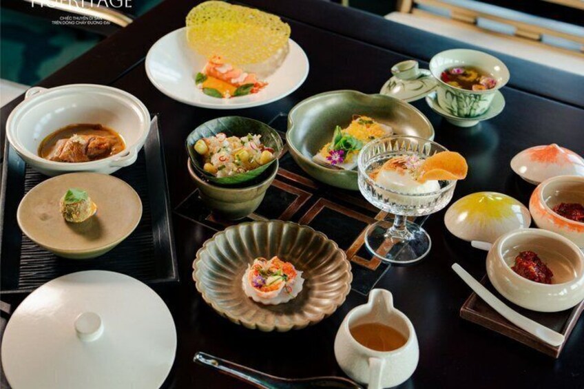 A variety of dishes on a table, including a bowl of soup, a plate of sushi, and a glass of tea. 1