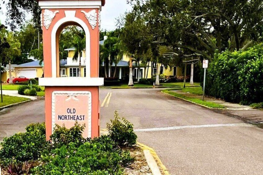 A street sign labeled 'Old Northeast' with a clear road, residential houses, and lush greenery. 5