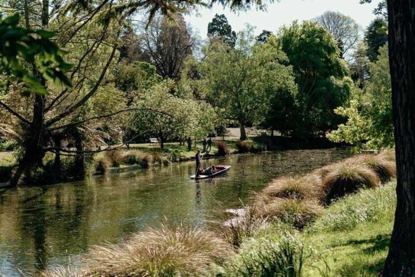 A calm river with a boat, surrounded by lush greenery and trees. 4