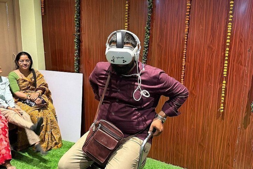 A person in a purple jacket and beige pants sitting on a scooter with a helmet and headphones. 3