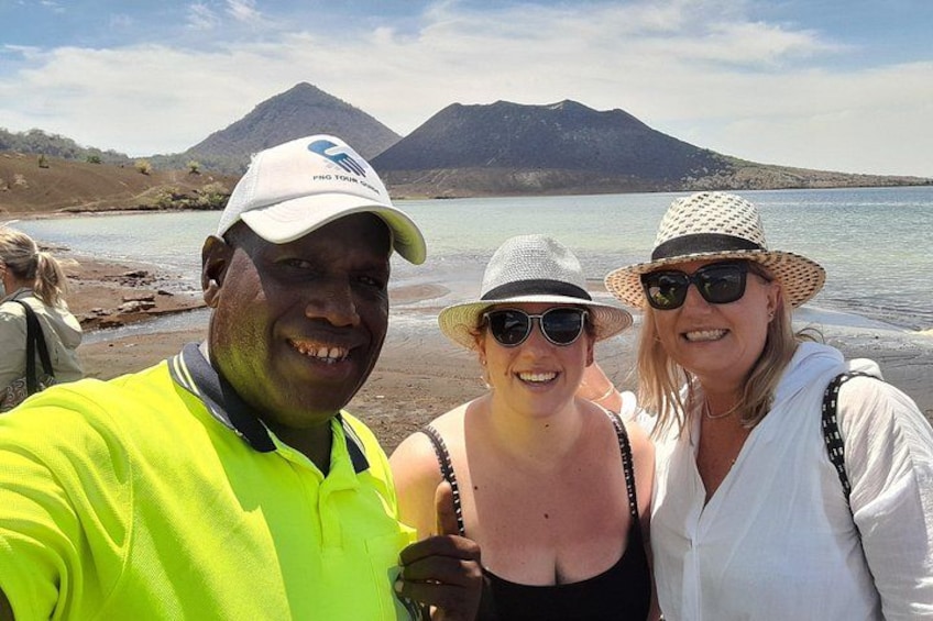 Three people near a body of water with mountains in the background. 4